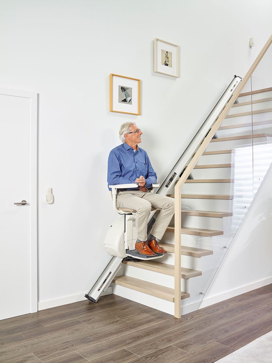 Sanitätskaufhaus Kellner - Relaunch 2025 - Alter Mann sitzt auf einem Treppenlift und schaut die Treppe hoch