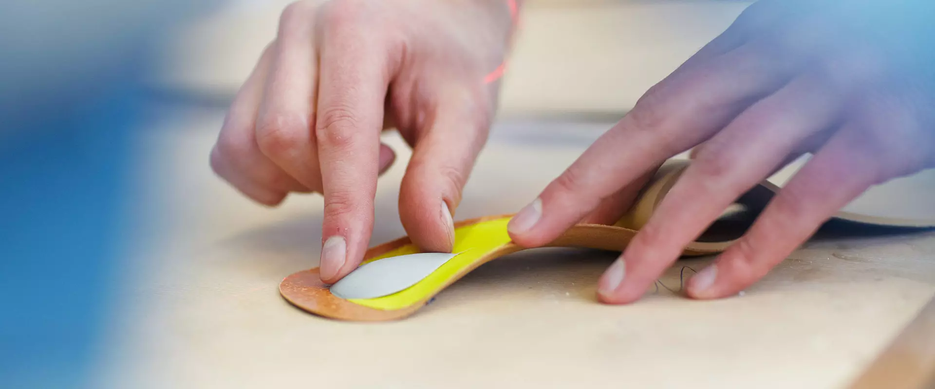 Sanitätskaufhaus Kellner - Relaunch 2025 - individuelle Einlagen - Einlagenanfertigung Detailaufnahme - Mitarbeiterhände fertigen Einlage an