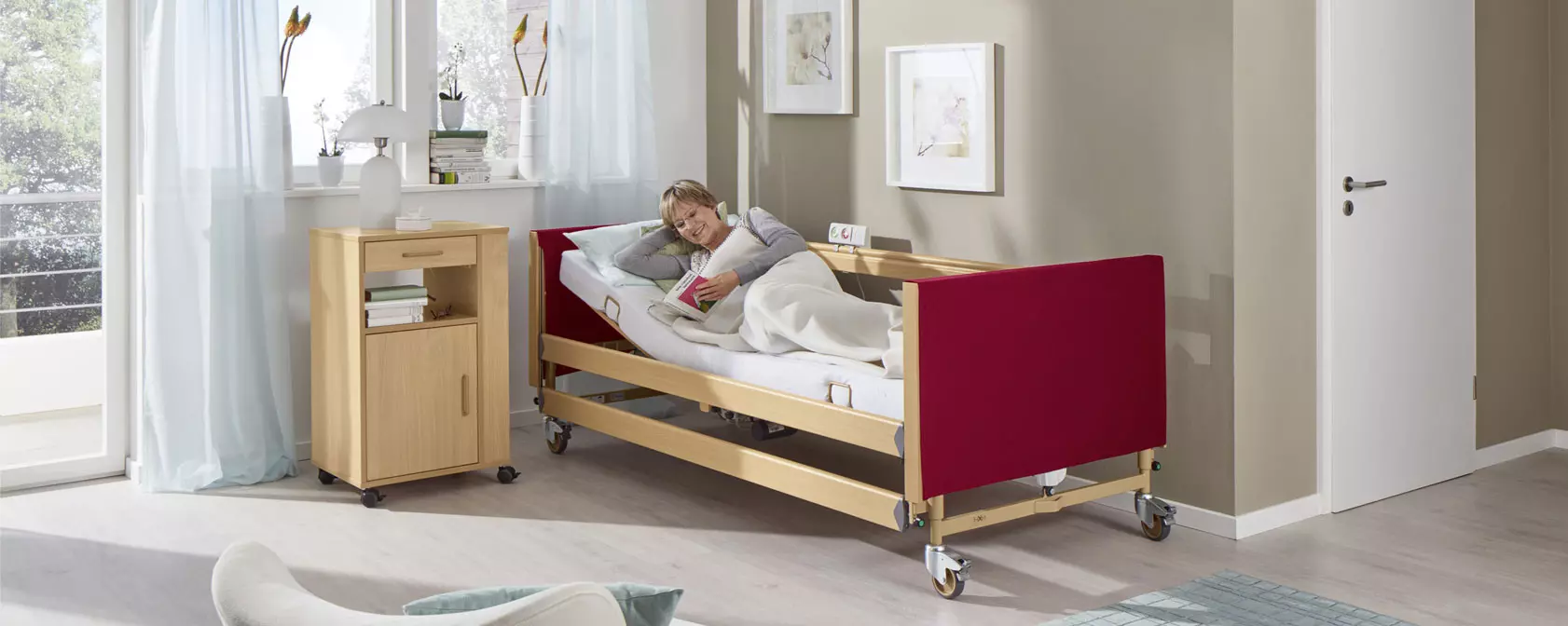 Sanitätskaufhaus Kellner - Relaunch 2025 - Kaufhaus - häusliche Pflege - Pflegebett in hellem Wohnraum - ältere Dame liest entspannt ein Buch