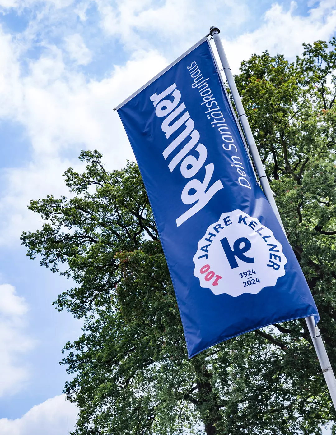 Sanitätskaufhaus Kellner - Relaunch 2025 - Über uns - Kellner Hissflagge vor der Niederlassung weht in Wind