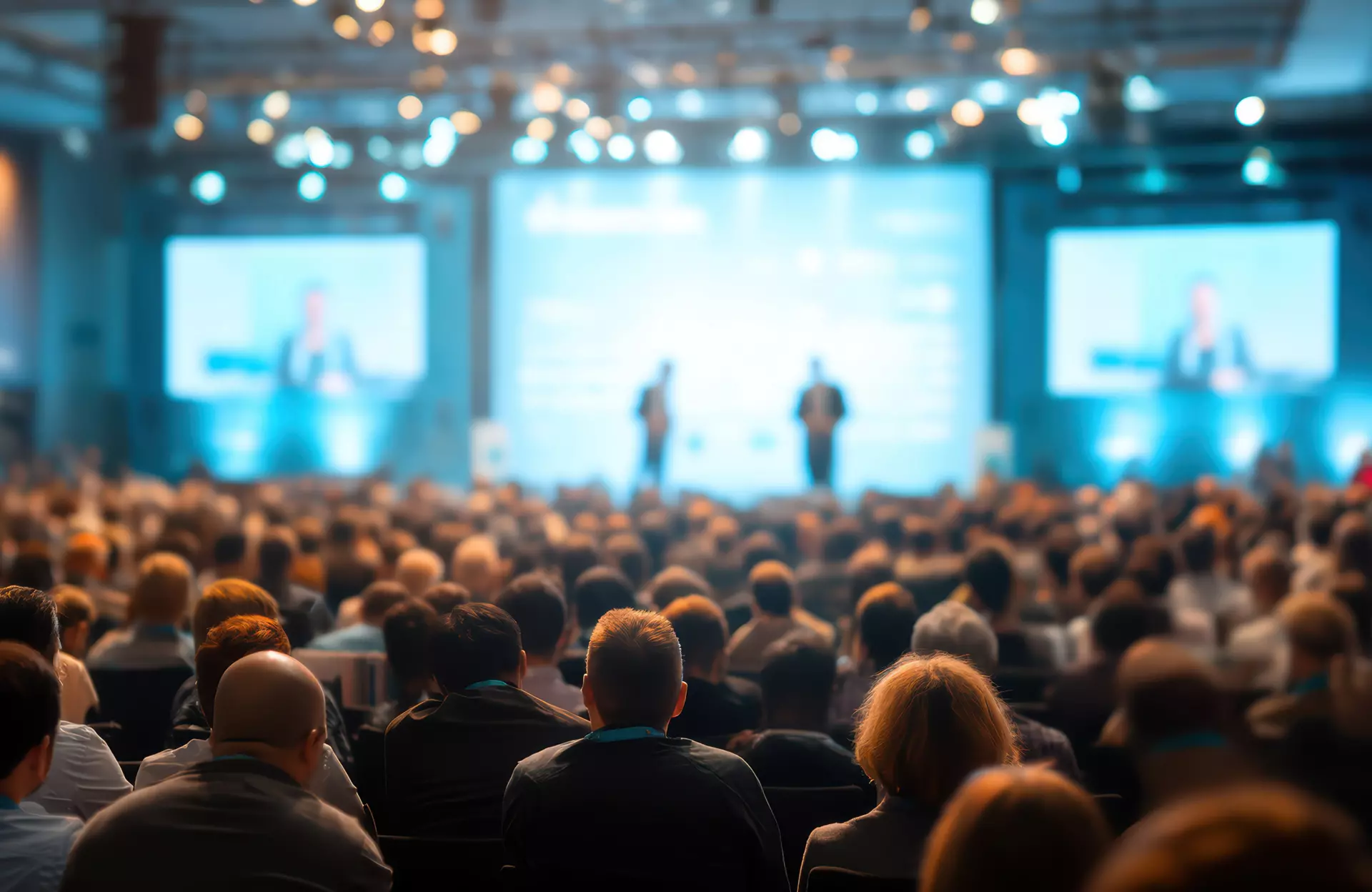 Sanitätskaufhaus Kellner - Relaunch 2025 - Stockmaterial - eine große Gruppe von Menschen schaut einem Vortrag auf einer Bühne zu